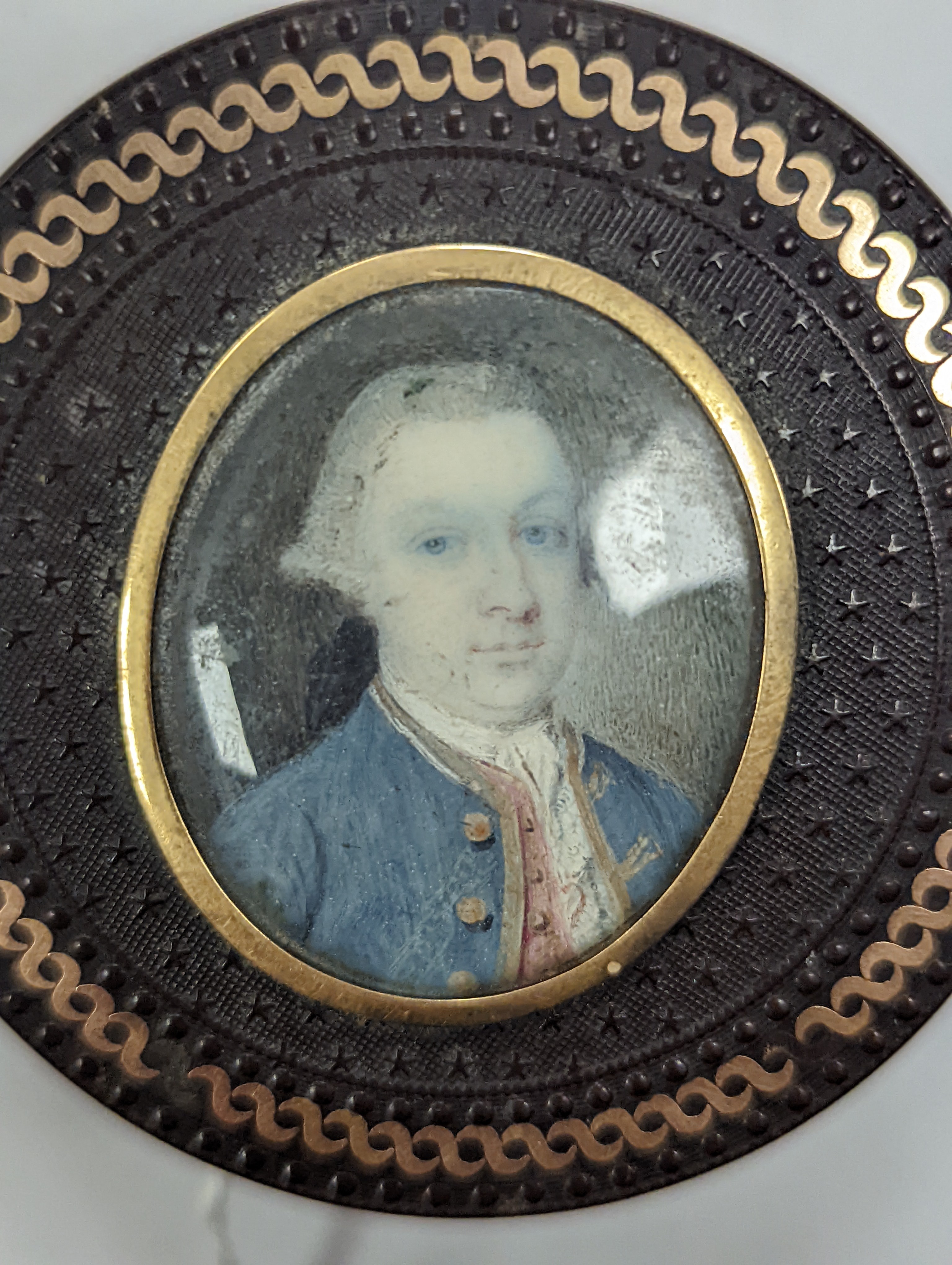 A 19th century pressed bois durci and gilt metal snuff box with painted miniature portrait of a gentleman on ivory to cover. 6cm diameter